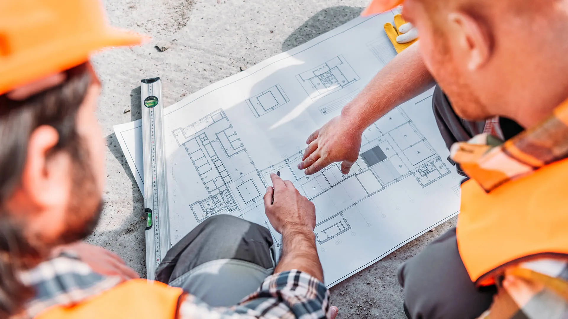 Ingenieros revisando planos arquitectónicos de un nuevo fraccionamiento residencial